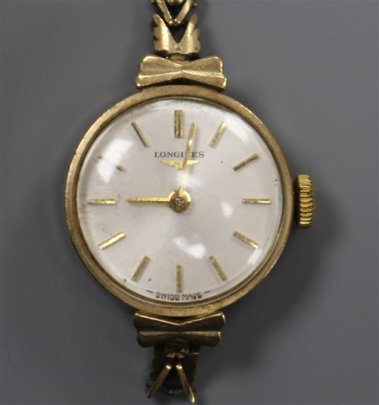 A ladys 9ct gold Longines manual wind wrist watch, on a 9ct gold bracelet (af).